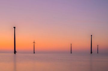 Windkraftanlagen in einem Offshore-Windpark bei Sonnenuntergang mit Langzeitbelichtung von Sjoerd van der Wal