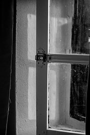 Window with sunlight filtering through the shade of a French cottage