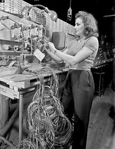 Frau überprüft technische Installation und Kontrolltafel bei Boeing 1942
