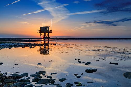 prachtige zonsondergang achter een vissershuisje aan het water in Scharendijke in de provincie Zeela