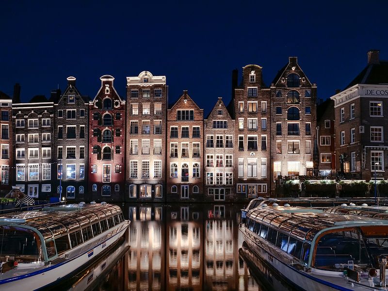 Amsterdam skyline, grachtenhuizen langs het water van het Damrak. van Ruurd Dankloff