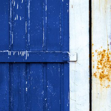 Abstract lijnenspel op een verweerd blauw deurpaneel