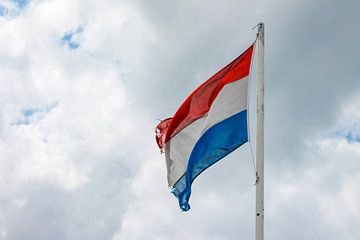 Trots in de lucht: Nederlandse vlag wappert tegen bewolkte hemel van Joy Mennings