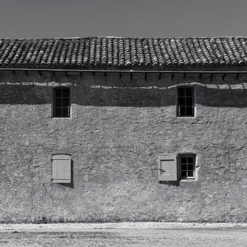 Photo en noir et blanc d'une vieille maison rurale avec volets et toit de tuiles en France sur Dina Dankers