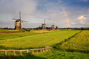 Drei Mühlen auf einer Wiese mit einem Regenbogen von iPics Photography