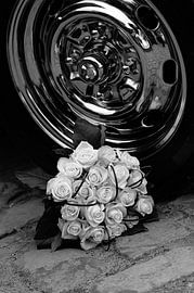 Élégant bouquet de roses blanches à côté d'une jante chromée polie en noir et blanc