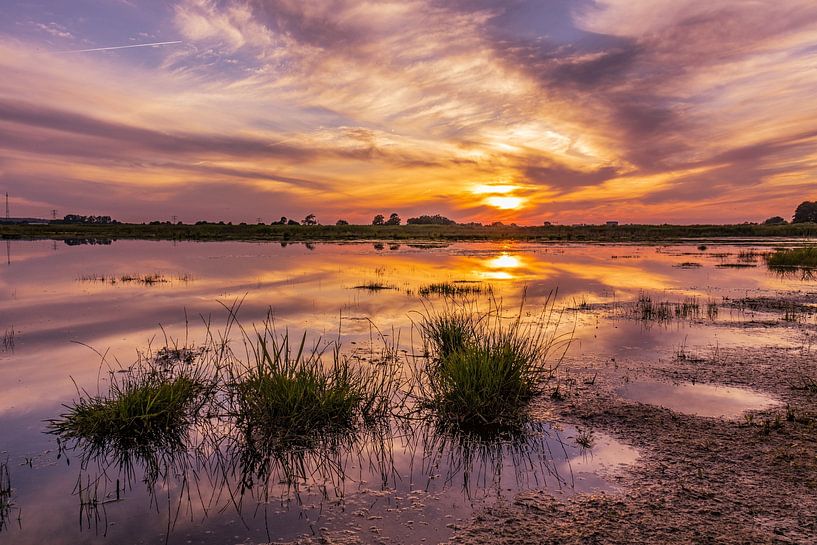 Zonsondergang met reflectie in het water. van Rick van de Kraats