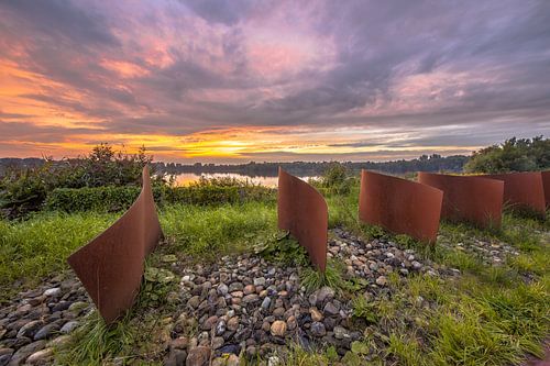 Metal wave objects in landscape with lake and sunset at Piccardthofplas Groningen city, Netherlands