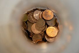 Close-up of European coins in a bottle from above