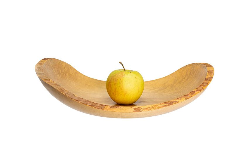 Side view of a flat wooden bowl with an apple in the middle exposed on white by Hans-Jürgen Janda