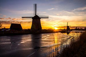 Moulin à Alkmaar avec glace sur le fossé au coucher du soleil