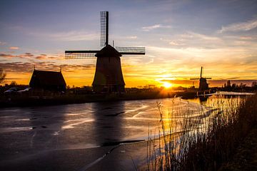 Mill in Alkmaar with ice on the ditch at sunset