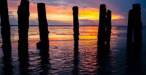 Golfbrekers in de Waddenzee. Zonsondergang aan de Noordzee