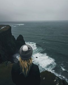 Junge Frau schaut über die Küstenlandschaft