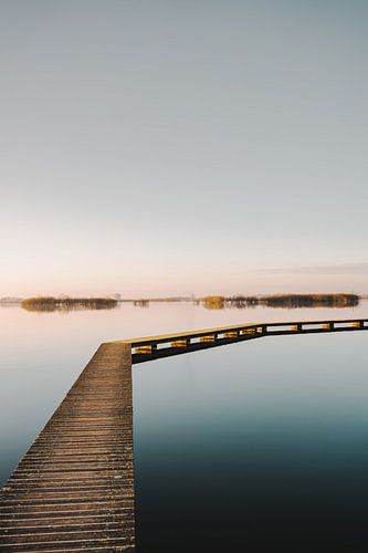 Vlonderpad over water bij zonsondergang