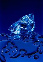 Smeltend ijsblok in blauwe omgeving,