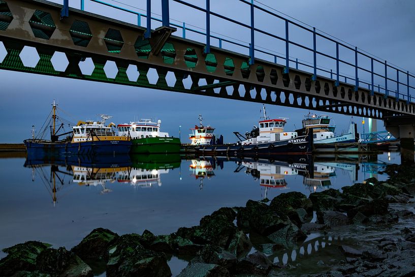 Stille avond in de haven van Den Oever waarbij kleurrijke vissersboten reflecteren in het water van Bram Lubbers