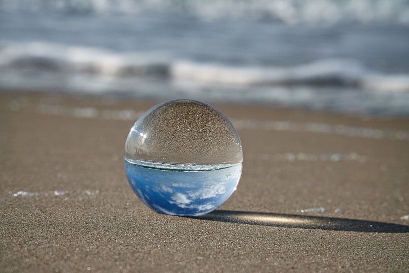 View through the glass ball on the beach. Sea and sky in the background. by Martin Köbsch