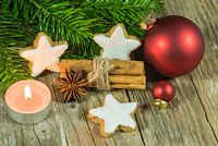 Weihnachtskomposition aus Sternkeksen, Gewürzen, Kerzenlicht, roten Kugeln und Tannenzweigen