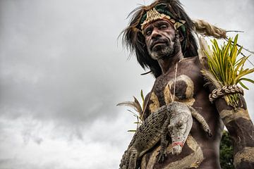 Man met krokodil op krokodillenfestival in Papua Nieuw Guinea.