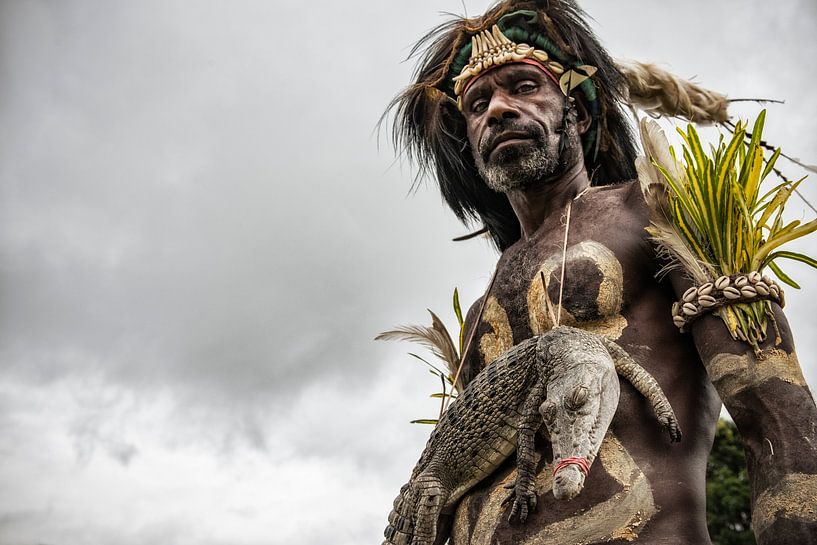 Man with crocodile at crocodile festival in Papua New Guinea. by Ron van der Stappen