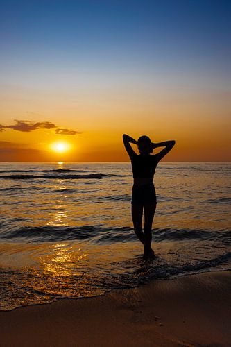 Dames silhouet tegen een kleurrijke zonsondergang