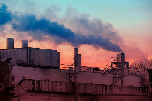 Cheminées fumantes d'une usine au coucher du soleil