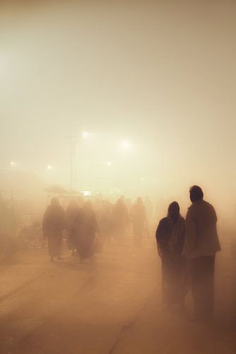 Mensen die in de mist lopen tijdens de Kumbh Mela in India