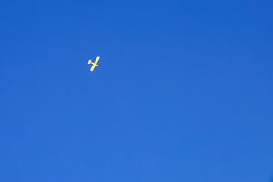 Avion jaune dans un ciel bleu et clair.