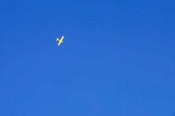 Geel vliegtuig in een heldere, blauwe lucht. van Erik de Rijk