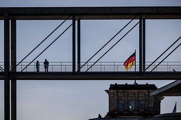 mensen op brug met de reichstag en duitse vlag in Berlin van Eric van Nieuwland