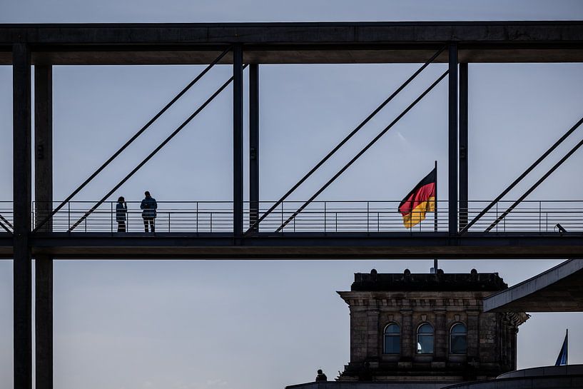 people on bridge with the reichstag and german flag in Berlin by Eric van Nieuwland