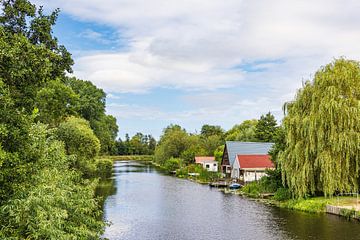 Uitzicht over de Warnow naar boothuizen in Schwaan van Rico Ködder