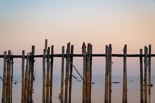 Mönch geht über eine hölzerne U-Bein-Brücke bei Mandalay in Myanmar.