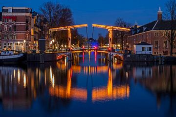 Stadsgezicht van Amsterdam aan de Amstel in Nederland bij avond van Eye on You