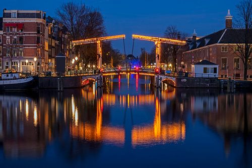 Stadsgezicht van Amsterdam aan de Amstel in Nederland bij avond