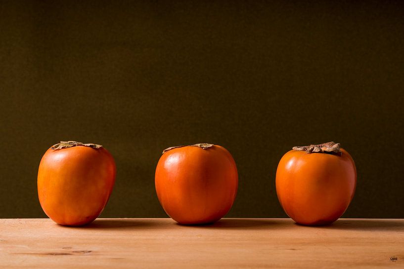 drei Sharonfruits hintereinander. von Lieke van Grinsven van Aarle