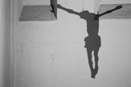 Shadow of a statue of Jesus on the wall by Studio Zwartlicht