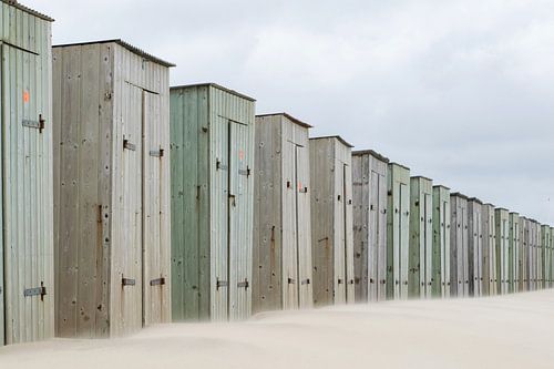 Rij met traditionele houten strand huisjes aan de Nederlandse kust. Zomer tafereel.