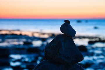 Stenen piramide aan de Baltische Zee met uitzicht op de zee bij zonsondergang en het blauwe uur