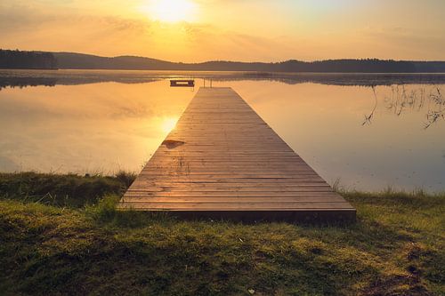 Loopbrug, naar de zonsopgang, reikend in een Zweeds meer