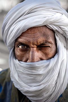 Knipogende Berber man op het Djemaa el Fna plein in Marrakech van Ingrid Koedood Fotografie