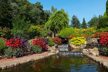 schöner Garten mit fünf Wasserfällen und blühenden Pflanzen