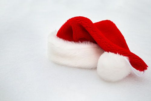 Eenzaam. Kerstmuts in de sneeuw.