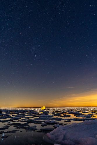 Orion boven de Waddenzee met ijschotsen