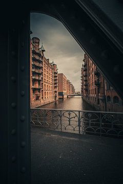 Die Speicherstadt aus rotem Backstein, eingerahmt vom Fachwerk der Brücke von Jonas Röjestål