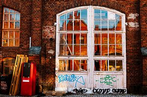 Weißes Rundbogenfenster in rotem Backstein – Spiegelungen & urbaner Charme