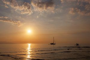 Mooie schemering op het strand en silhouet van vissersboot en zeilboot
