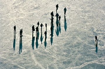 Luchtopname van winterlandschap, een groep mensen schaatst op de Vinkeveense Plassen