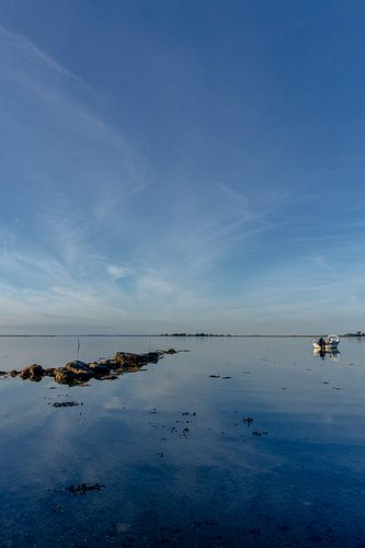Reisfotografie  - rustige zee met rotsen en een bootje